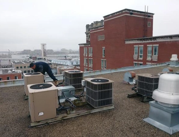 Technician servicing rooftop units, showcasing top-rated HVAC services for commercial building systems.