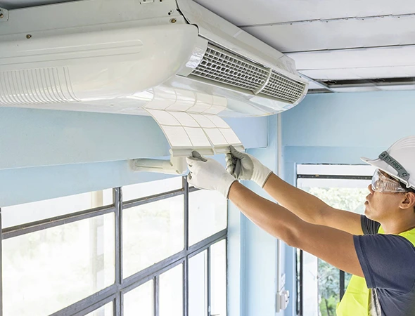 Technician inspecting AC unit during professional air conditioning service for optimal system performance.