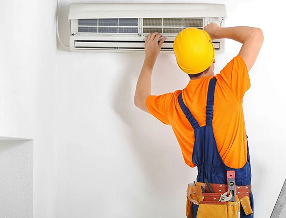 Technician replacing a faulty thermostat during professional AC repair service to restore cooling efficiency.