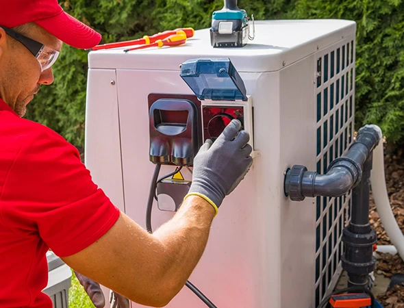 Technician in red shirt repairing HVAC system for efficient heating and cooling performance.