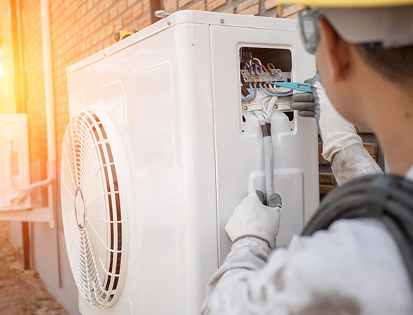 Technician performing HVAC repair during professional heat pump services to restore efficient heating and cooling.
